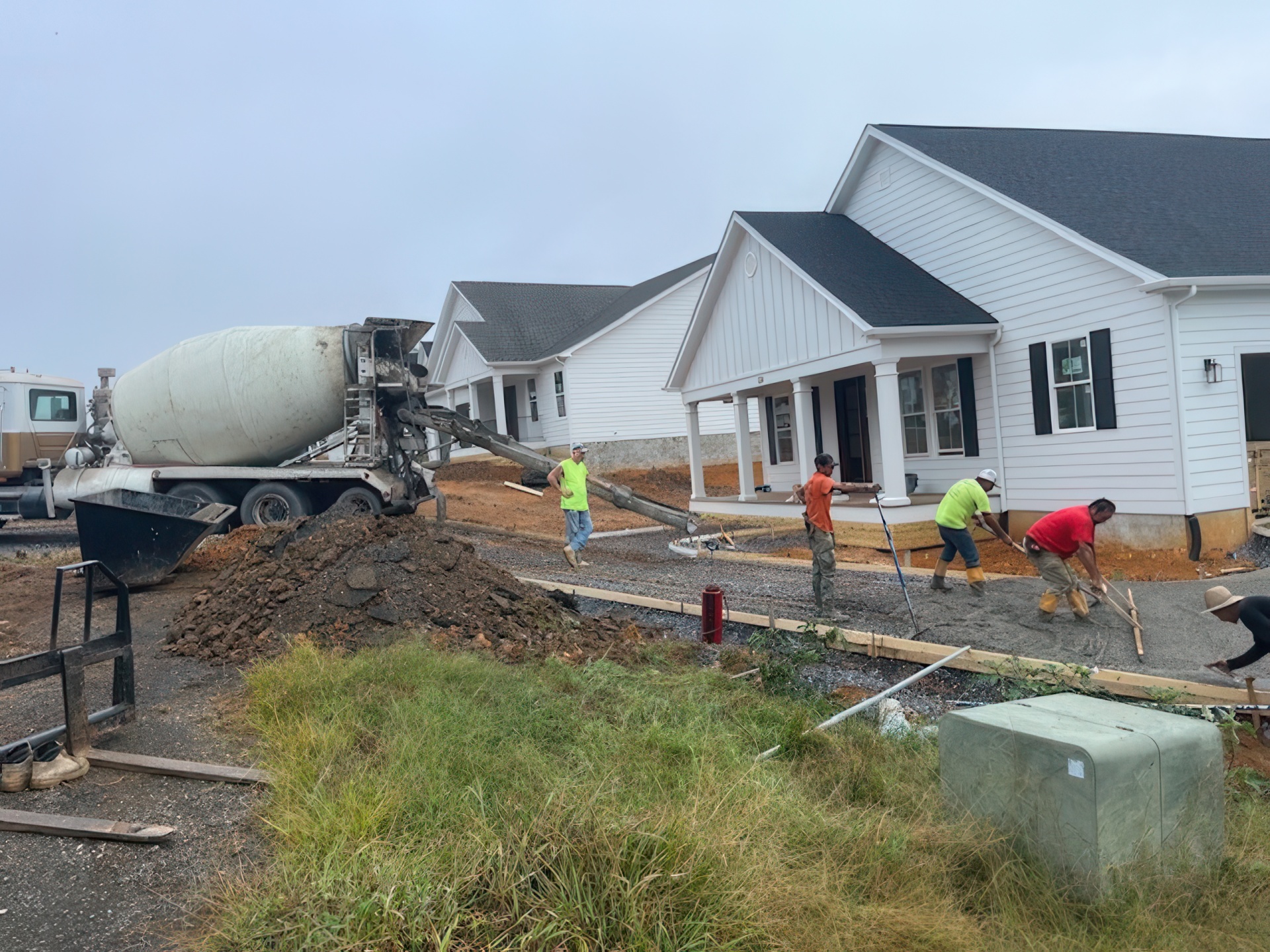 House on residential site with CW Barger employees  spreading concrete 
